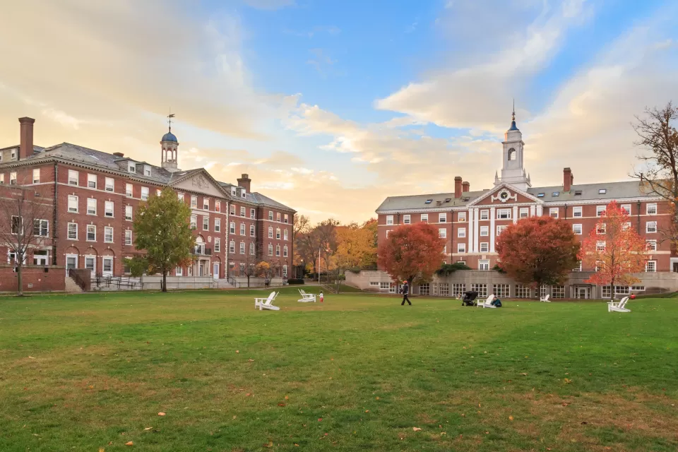 View of wide green lawn in front of red brick four-story buildings on Harvard University campus